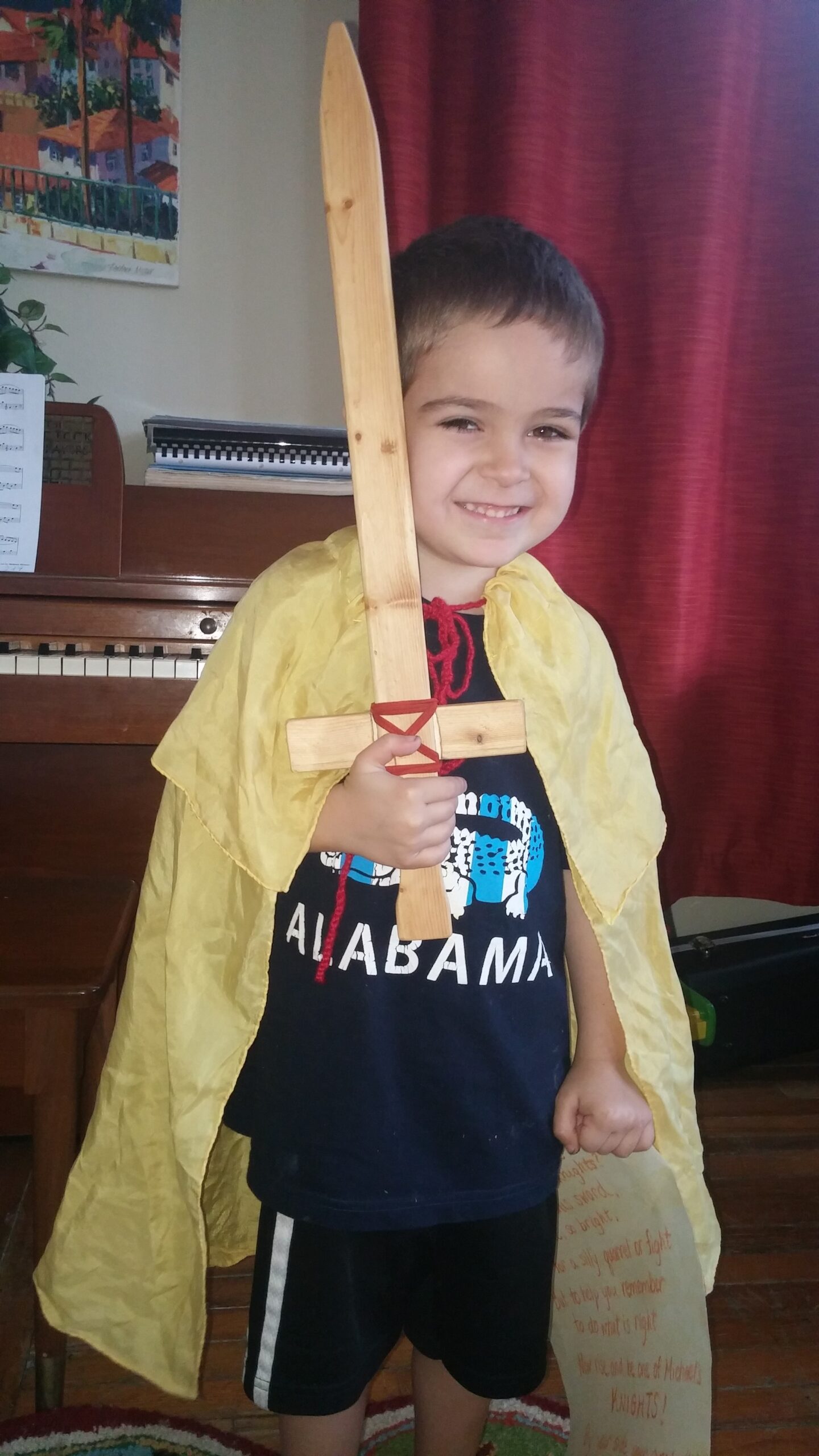 A boy in a golden cape holding a wooden sword for Michaelmas