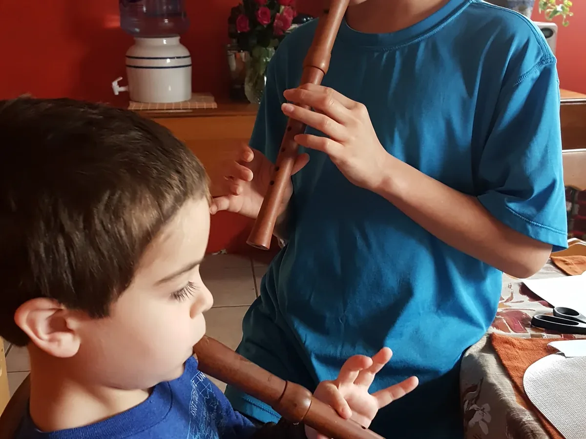 Two children playing recorders together